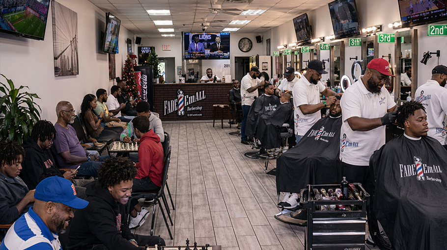 Busy Fade 'Em All barbershop floor with barbers and clients